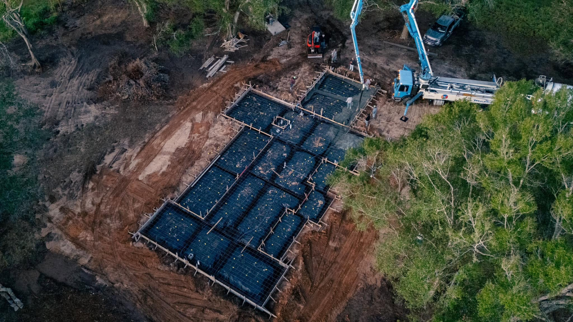 Angled aerial view of a large reinforced foundation prepared for concrete